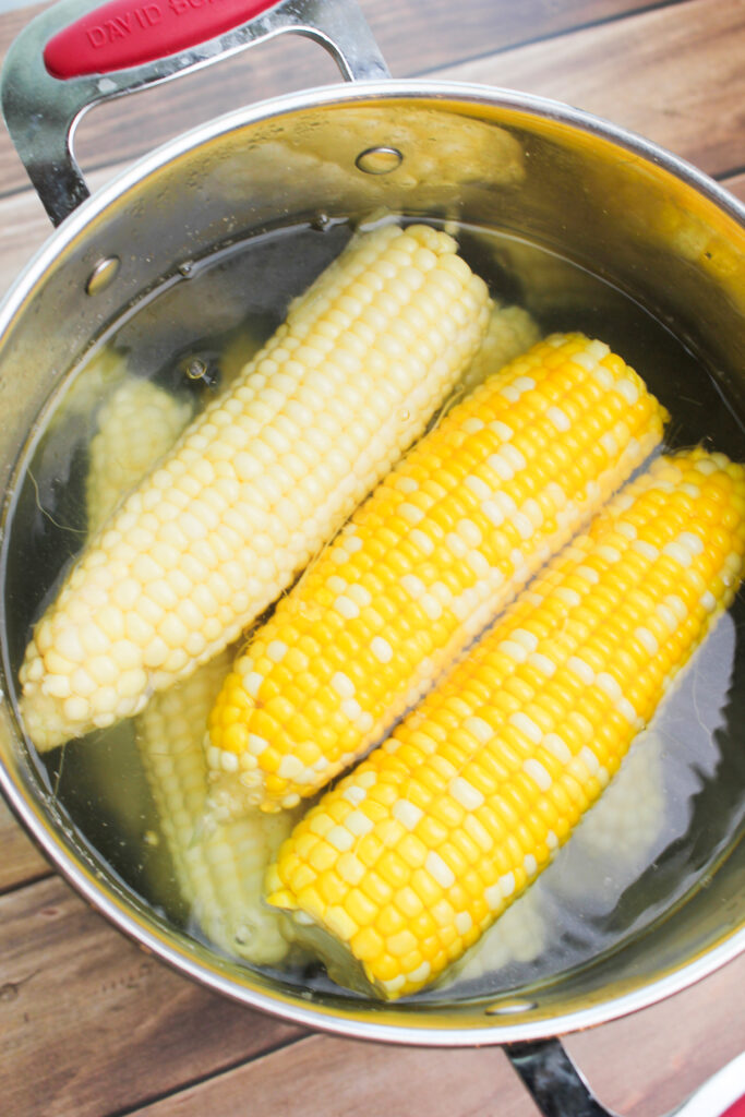 The corn boiling in a pot.