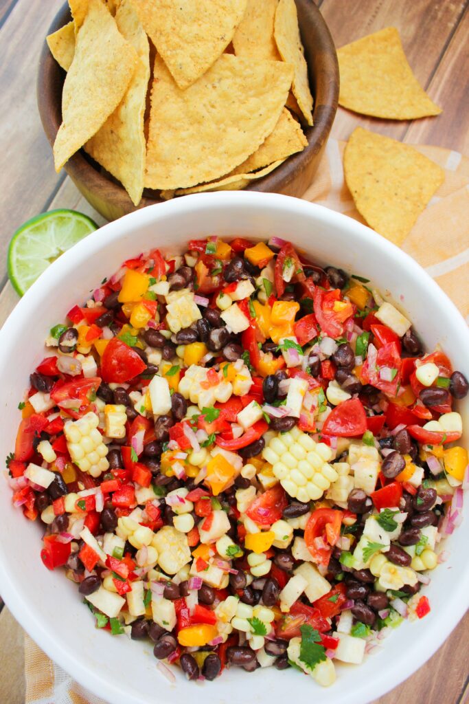 The black bean salsa is in a large bowl with tortilla chips and is ready to eat.