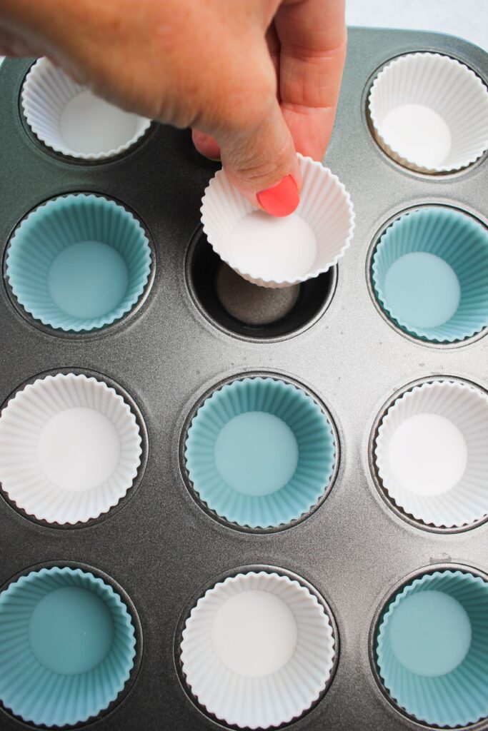 Placing the mini silicone cupcake liners into the pan.