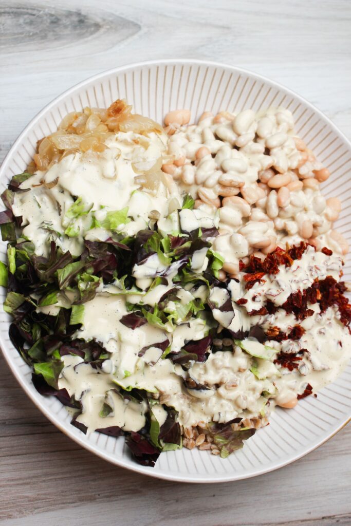 The dressing is poured over a bowl of salad.