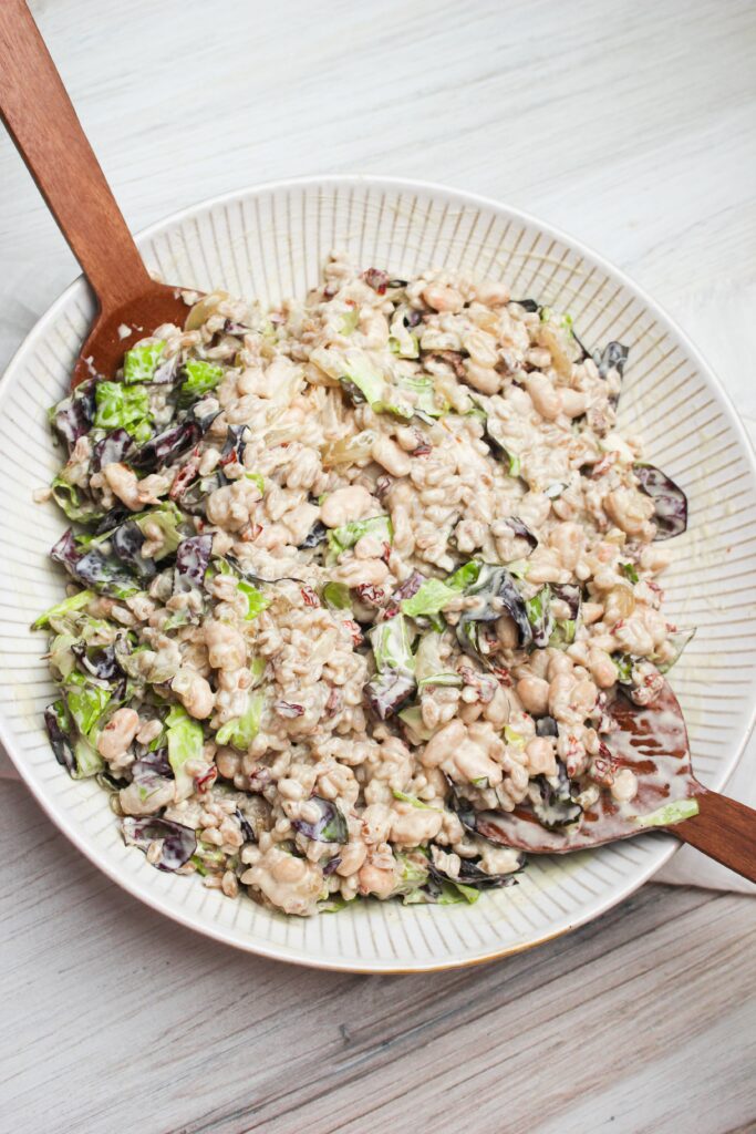 The salad has just been tossed in dressing and is ready to eat. Served in a large bowl.