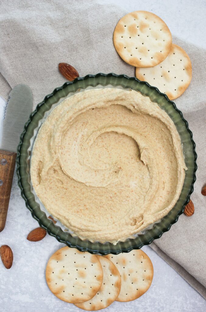 A bowl of the almond dip served with crackers.