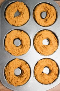 The batter has been poured into each donut mold and is ready for the oven.