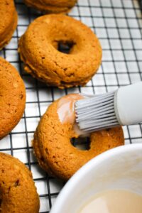 Spreading glaze onto a donut.