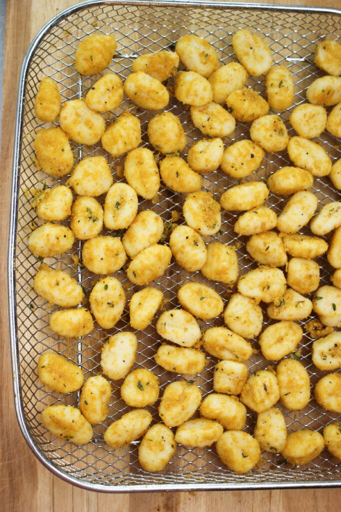 THe gnocchi is in a flat layer in the basket and is ready to be cooked.