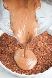 Pouring chocolate filling onto the pie crust.