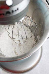 Whipping the coconut milk in the bowl of a stand mixer to make the chocolate whipped cream.