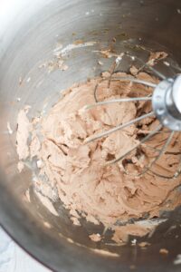 The whipped cream has been whipped in a large mixing bowl and is ready to enjoy.