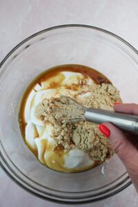 Mixing the yogurt based ingredients in a glass jar with a whisk.