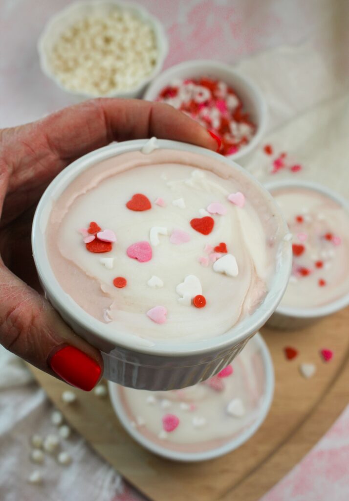 Holding one ramekin of the protein pudding.