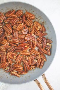 The pecans are cooking in a small fry pan.