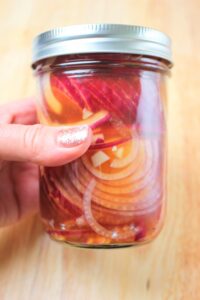 The pickled onions in a mason jar.