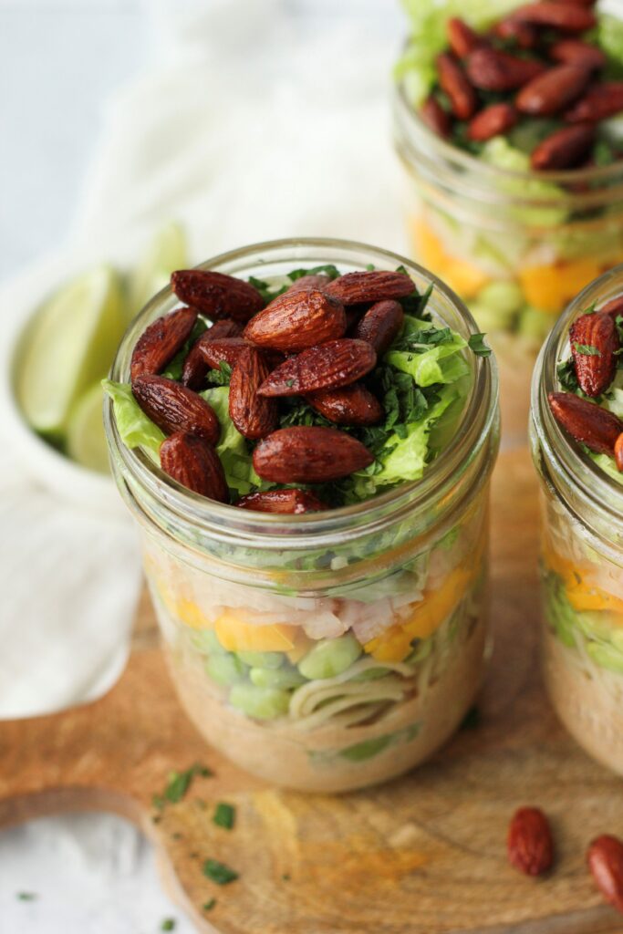 A picture of one mason jar filled with this Thai noodle salad.