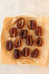 The dates are opened and on a plate lined with parchment paper.