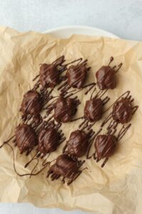 The dates have all been dipped in chocolate and are on a plate and ready to go into the fridge to harden.