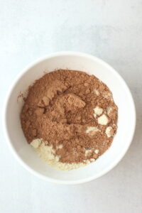 All of the ingredients for the chocolate layer are in a bowl ready to be mixed.