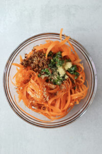 All of the ingredients in a glass bowl are ready to be tossed.