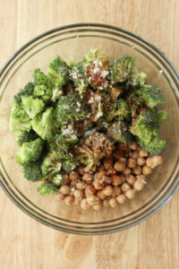 The broccoli and chickpeas are in a bowl and ready to be tossed with seasonings.