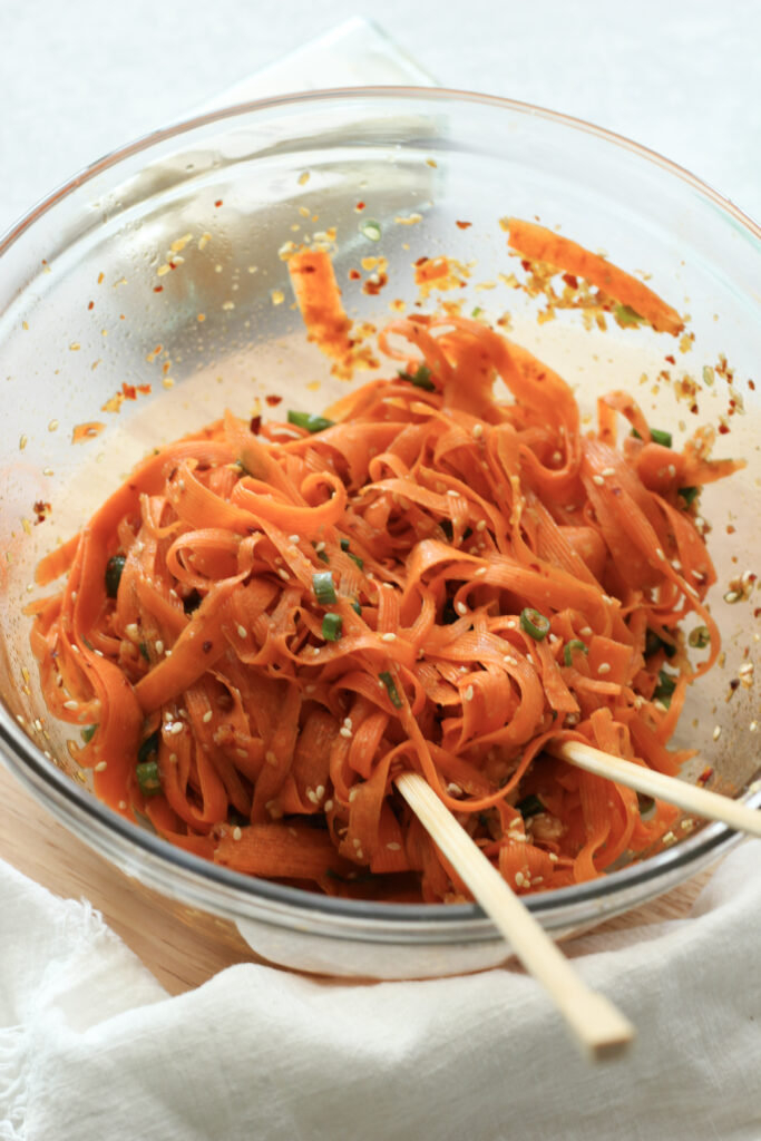 Eating this carrot salad with chopsticks.