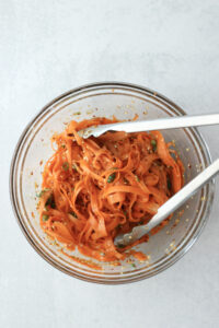 All of the ingredients have been tossed with tongs.