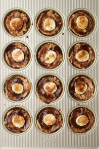 The muffins have been topped with the glaze and banana slices.