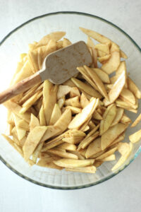 All of the ingredients have been added to the large bowl of apple slices for the filling.