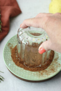 Covering the glass rim in cinnamon and sugar.
