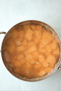 The sweet potato chunks are in a pot of salted water ready to boil.