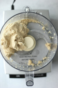 The ball of dough has formed in the food processor.