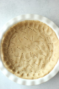 The dough has been evenly pressed into the pie dish.