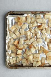 The bread cubes have been toasted on a baking sheet.