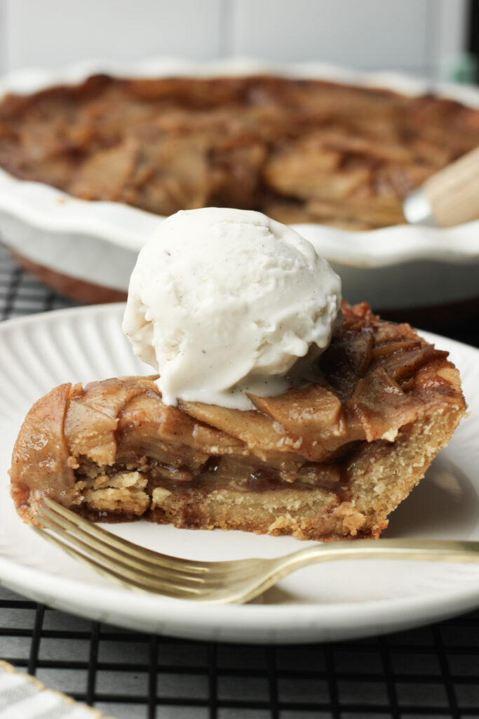 An up-close picture of a slice of apple pie with a scoop of vanilla ice cream.