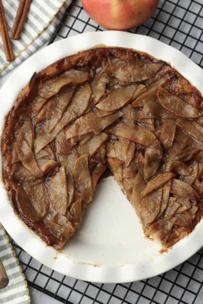 A picture of the apple pie with one slice eaten.