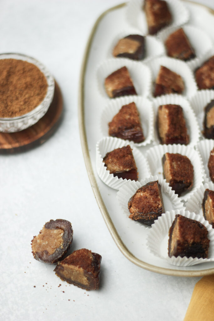 The cinnamon sugar-stuffed dates have been cut in half and placed in mini cupcake liners.