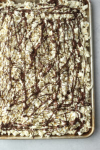 The melted chocolate has been drizzled over the popcorn.