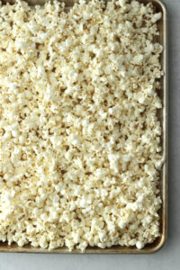 The popcorn has been transferred to a lined cookie sheet.
