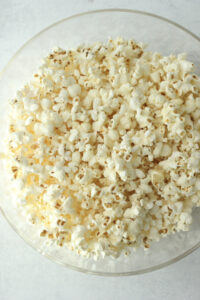 The popcorn has been popped and placed in a large, clear bowl.