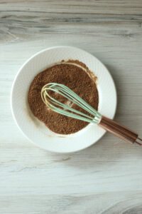 Cinnamon and sugar are mixed in a small bowl.
