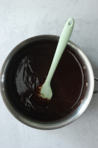The ganache is creamy and melted in a saucepan and is ready to pour over the rice krispies.