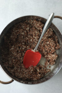 The rice krispie mixture has been mixed in a large pot and is ready to be transferred to a casserole dish.
