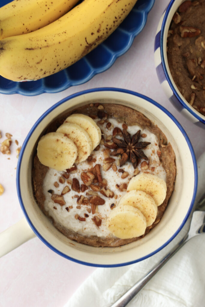 A blue mug with a finished sticky vegan banana bread mug cake.