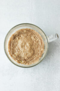 The mug cake has been cooked in the microwave for two minutes.