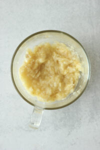 A banana has been mashed at the bottom of the mug.