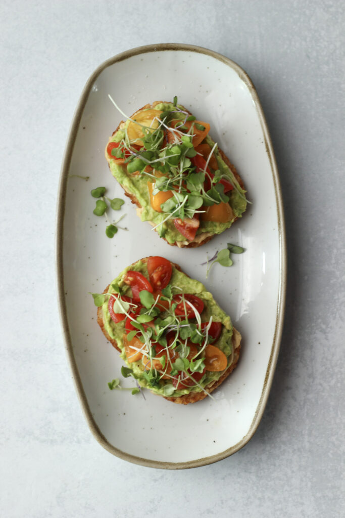 Two breakfast toasts are on a gray plate and are ready to eat.