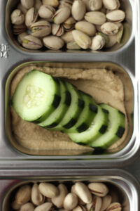 The cucumber slices and hummus have been added.