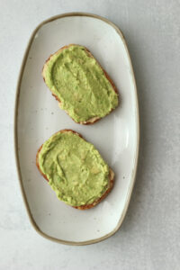 Next, a layer of avocado was spread over the hummus.