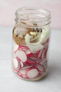 All of the solid ingredients have been added to a large mason jar.