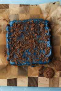 The crushed chocolate cookies have been added to the top of the frosting.