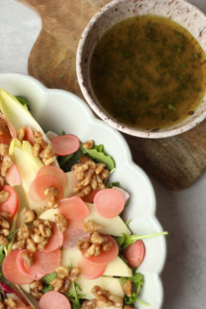 An up-close picture of a bowl of this dressing and a big bowl of salad to pour it on.