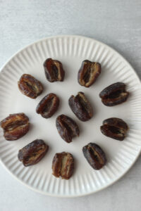The dates have been sliced and placed on a large white plate.